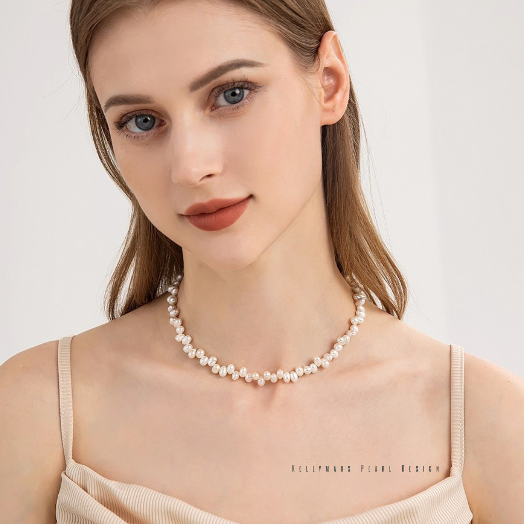 Unique offset design of the Faye natural baroque pearl necklace in shimmering 18K gold plating